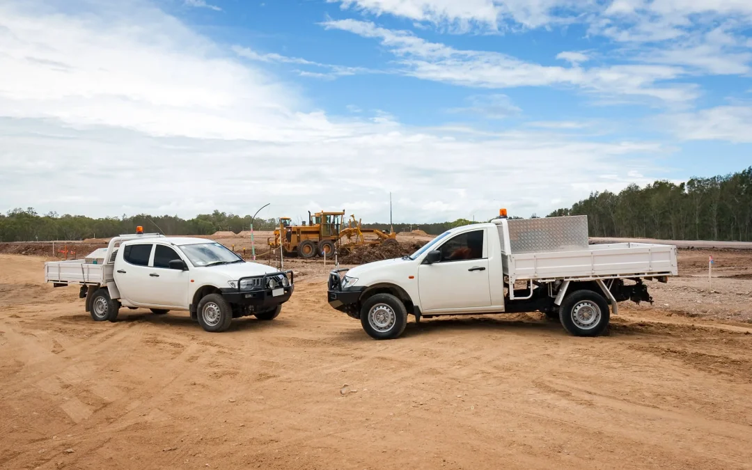 Two white utes on a construction site financed with the help of an equipment finance broker in Australia WA