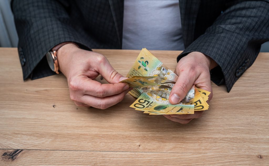 Businessman Hands Counting Fifty Australian Dollar Banknotes for Budget Planning and Savings
